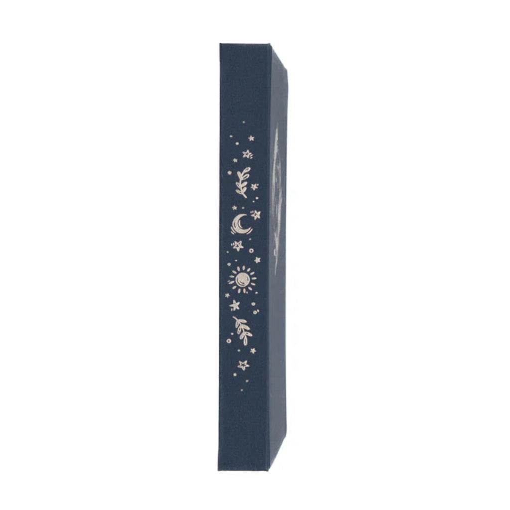 Side view of navy blue Archer & Olive notebook with celestial designs on a white background, available at Lighthouse Paper Co. in Melbourne, FL