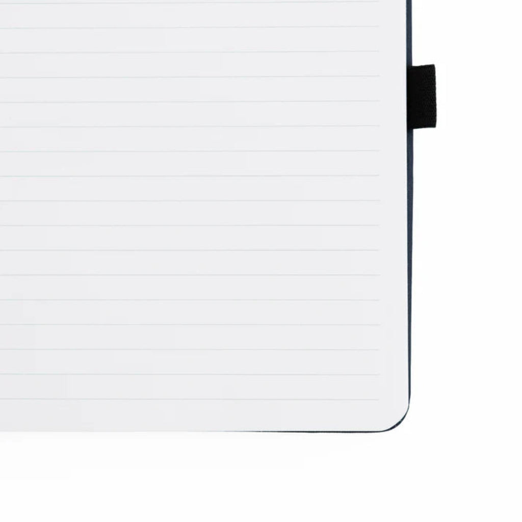 Corner of a lined Archer & Olive Forest Foxes notebook with a black pen strap on white paper, available at Lighthouse Paper Co. in Melbourne, FL