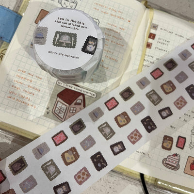 Decorative washi tape with small square stickers on a notebook