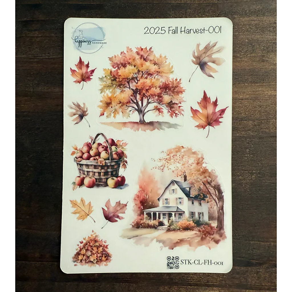Sticker sheet with autumn-themed designs including trees, leaves, and a house on a wooden surface.