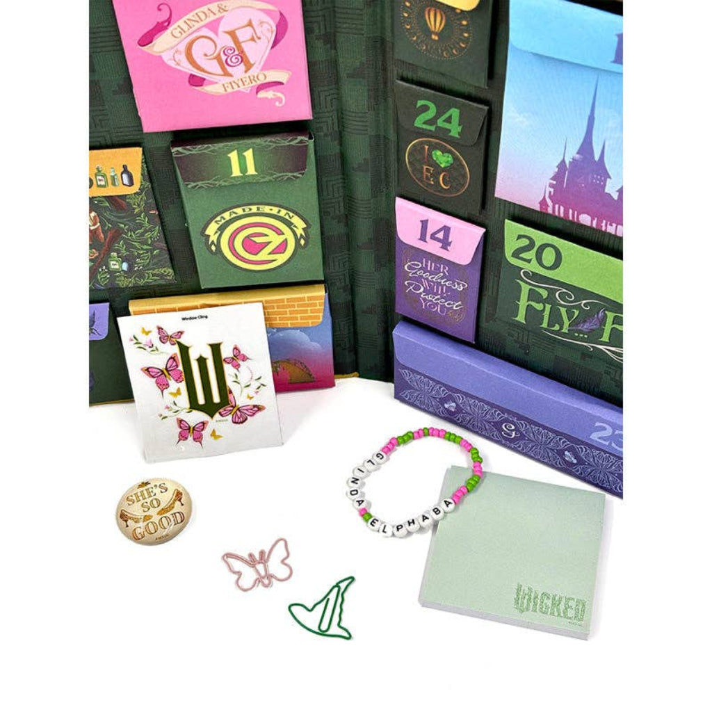 Collection of 'Wicked' themed items including a calendar, bracelet, and stationery on a white background.