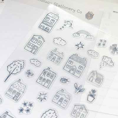 Sheet of black line art stickers featuring houses, trees, and other elements on a white background.