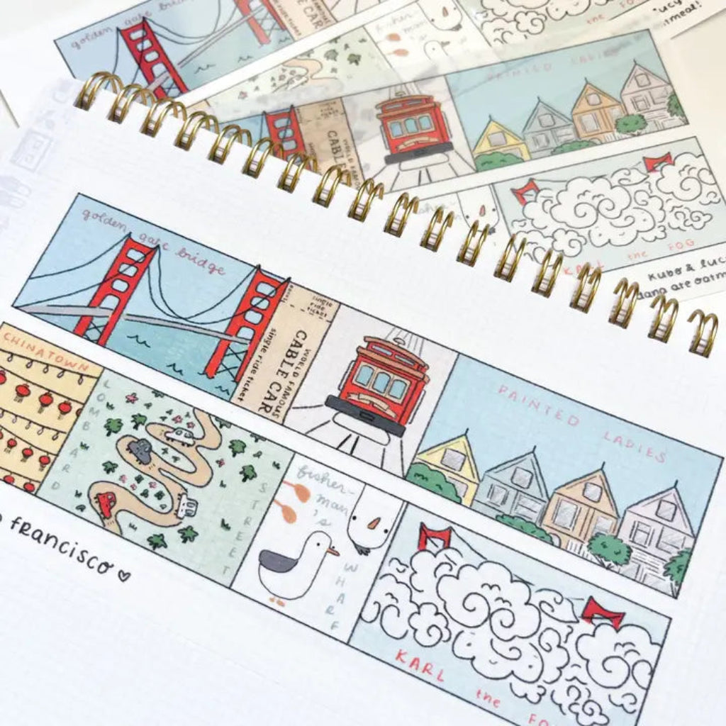 Spiral-bound notebook with illustrated pages featuring landmarks and scenes, on a white background.