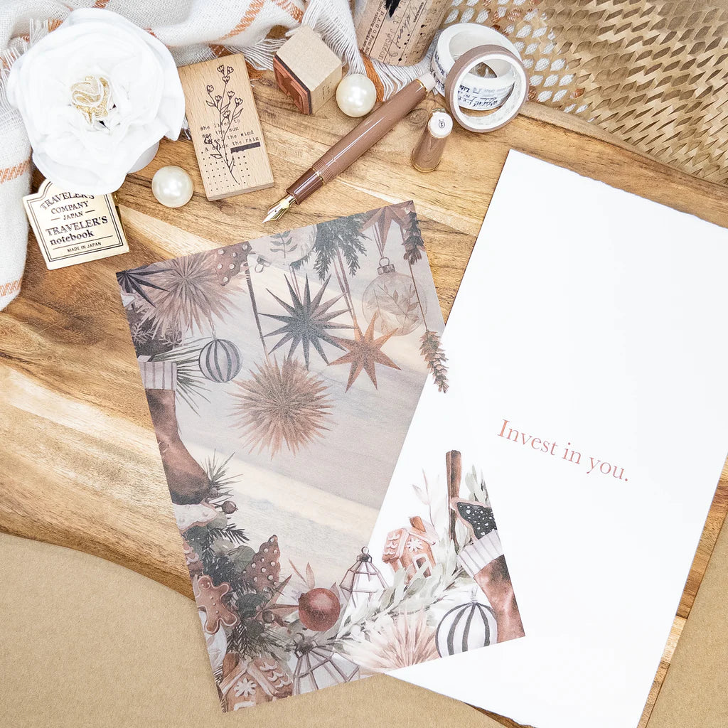 Stationery items including a notebook, pen, and motivational card on a wooden surface.