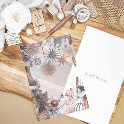 Stationery items including a notebook, pen, and motivational card on a wooden surface.