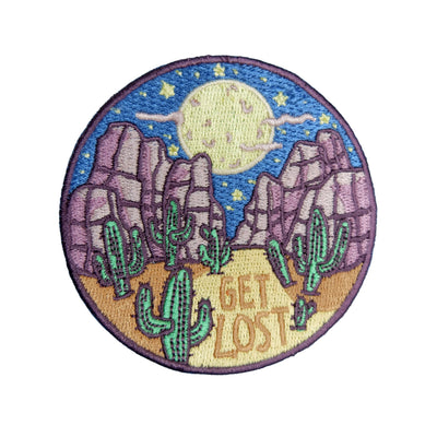 Round patch with desert landscape, cacti, and 'Get Lost' text on a white background