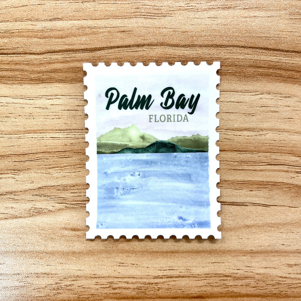 Stylized stamp with 'Palm Bay Florida' text and coastal design on a wooden surface