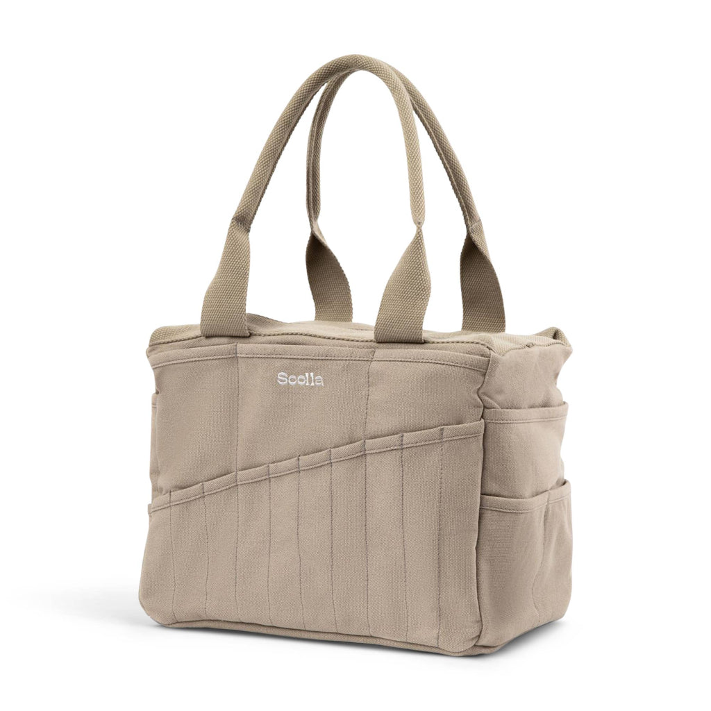 Beige tote bag with multiple pockets and handles on a white background