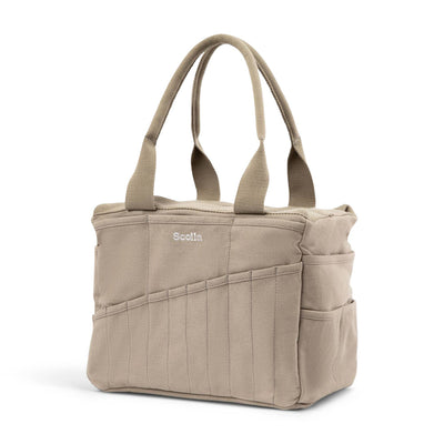 Beige tote bag with multiple pockets and handles on a white background