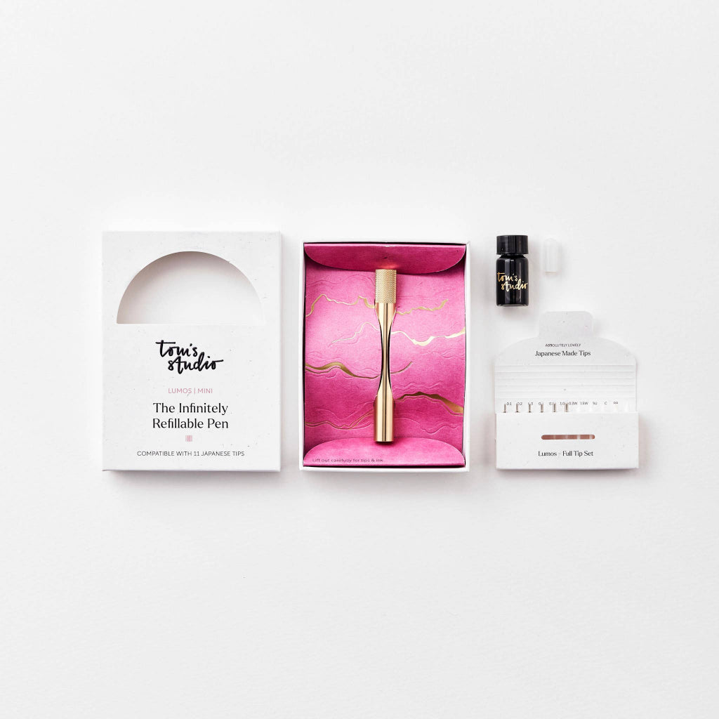 Gold pen in a white box with pink interior on a white background
