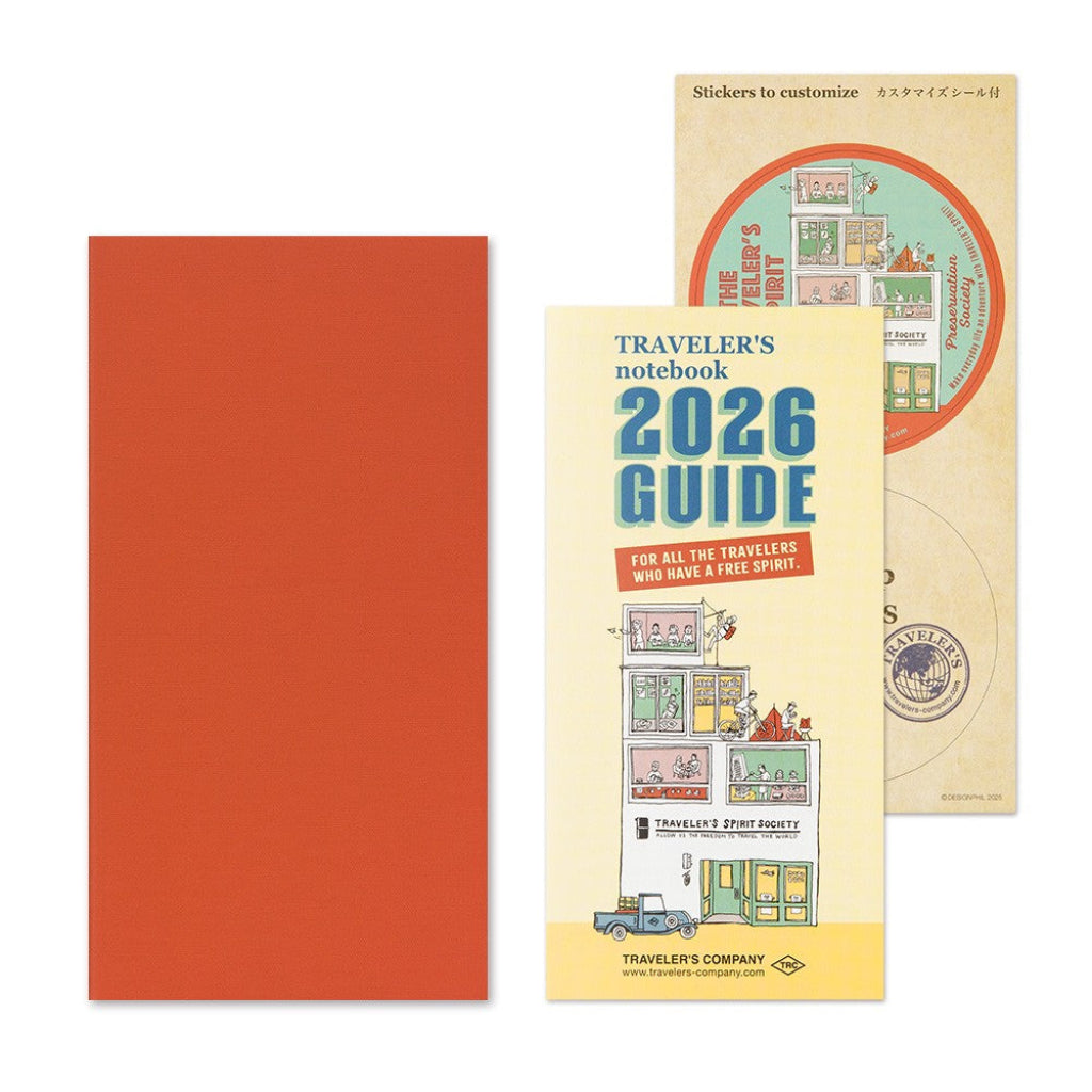 Traveler's notebook set with red cover, yellow guidebook, and small circular item on a white background