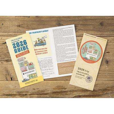 2026 guide and travel notebook on a wooden surface