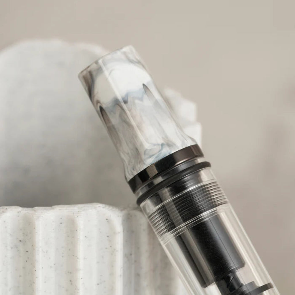 Close-up of a clear and black cylindrical object on a textured surface